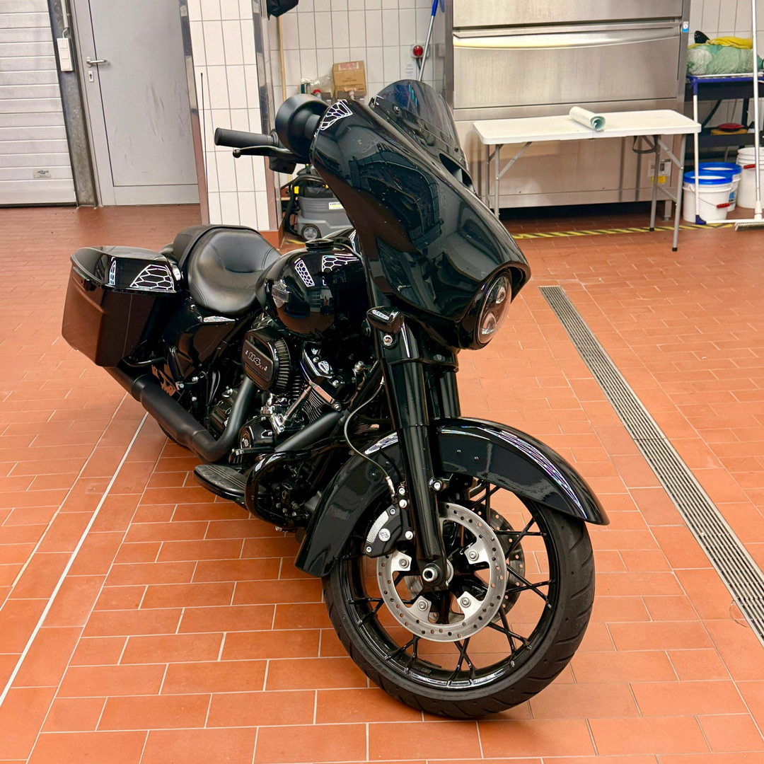 Schwarzes poliertes Motorrad in Werkstatt mit Geräten im Hintergrund